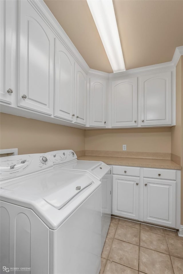 444 Grand Oaks Dr, Shreveport, LA 71106 - laundry area with washer and clothes dryer, cabinet space, and light tile patterned floors