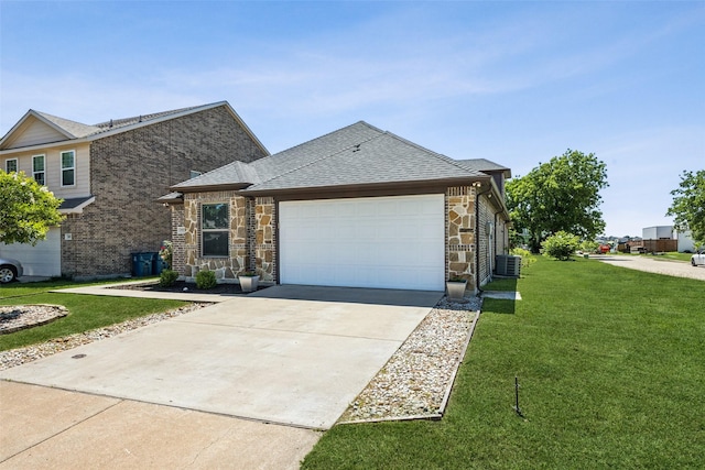 2405 La Costa Dr, Rowlett, TX 75088 - view of front of property with central AC unit, a front lawn, stone siding, an attached garage, and concrete driveway