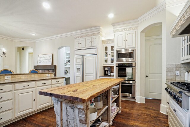 304 Van Oaks Dr, Colleyville, TX 76034 - kitchen featuring arched walkways, wood counters, built in appliances, white cabinets, and ornamental molding