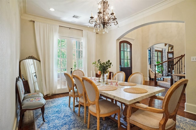 304 Van Oaks Dr, Colleyville, TX 76034 - dining area featuring arched walkways, a chandelier, dark wood finished floors, stairway, and ornamental molding