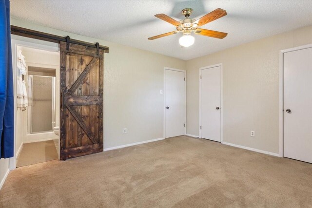 109 S Patricia St, Waco, TX 76705 - unfurnished bedroom with carpet, a barn door, baseboards, and connected bathroom