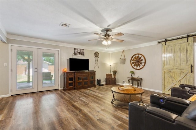 109 S Patricia St, Waco, TX 76705 - living room with a barn door, french doors, ceiling fan, wood finished floors, and baseboards