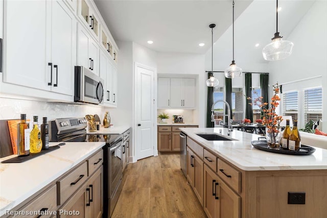 11760 Edgewood Dr, Justin, TX 76247 - kitchen featuring appliances with stainless steel finishes, a sink, light wood finished floors, recessed lighting, and an island with sink