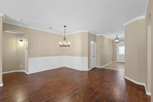 235 Carriage Dr, Willow Park, TX 76087 - empty room featuring a chandelier, hardwood / wood-style flooring, arched walkways, a wainscoted wall, and ornamental molding