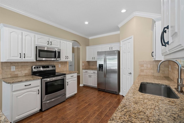 235 Carriage Dr, Willow Park, TX 76087 - kitchen with stainless steel appliances, a sink, crown molding, dark wood-style floors, and light stone counters