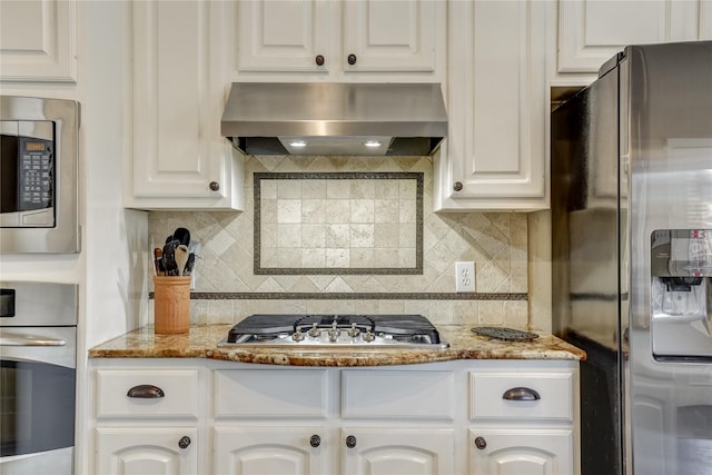 3401 Beckingham Ct, Flower Mound, TX 75022 - kitchen with appliances with stainless steel finishes, wall chimney exhaust hood, white cabinetry, and decorative backsplash