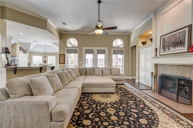 3401 Beckingham Ct, Flower Mound, TX 75022 - living area with a ceiling fan, a tile fireplace, ornamental molding, and baseboards