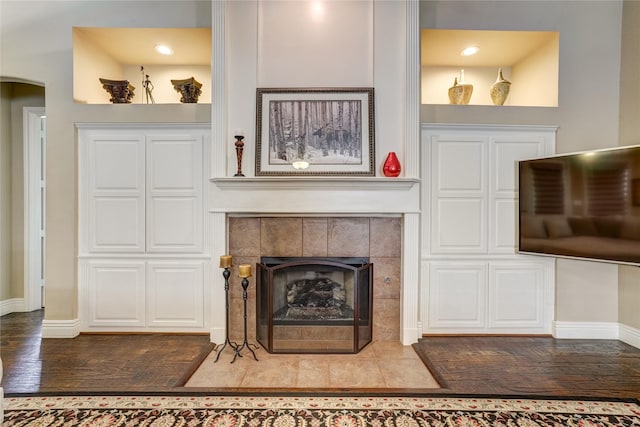3401 Beckingham Ct, Flower Mound, TX 75022 - living area featuring baseboards, wood finished floors, a tiled fireplace, and arched walkways