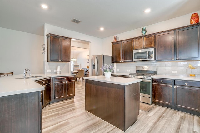 6100 True Vine Rd, Fort Worth, TX 76123 - kitchen featuring stainless steel appliances, a sink, light wood finished floors, a peninsula, and recessed lighting