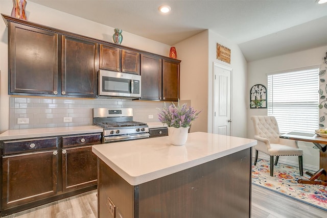 6100 True Vine Rd, Fort Worth, TX 76123 - kitchen with appliances with stainless steel finishes, light wood-style flooring, vaulted ceiling, tasteful backsplash, and dark brown cabinets