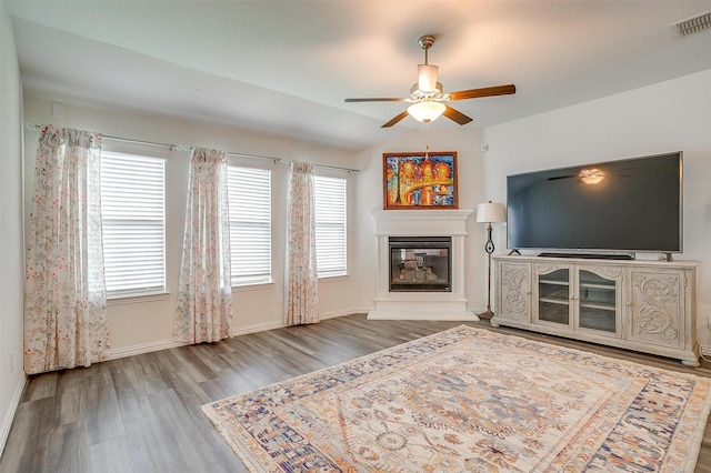 6100 True Vine Rd, Fort Worth, TX 76123 - living area with a ceiling fan, wood finished floors, a glass covered fireplace, and baseboards