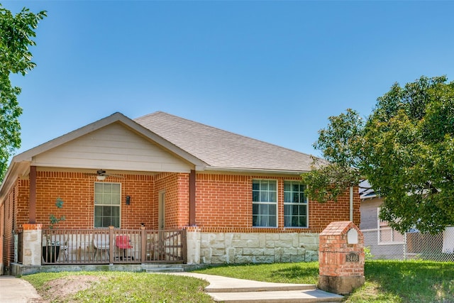 2446 Catherine St, Dallas, TX 75211 - view of front of house featuring a porch, a shingled roof, stone siding, and brick siding