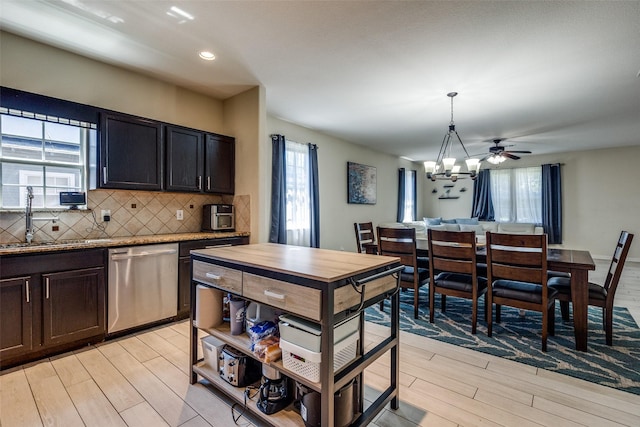 2446 Catherine St, Dallas, TX 75211 - kitchen featuring stainless steel dishwasher, a sink, light wood-type flooring, tasteful backsplash, and a chandelier