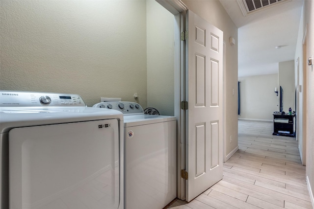 2446 Catherine St, Dallas, TX 75211 - laundry room with washer and dryer, light wood-style flooring, and baseboards