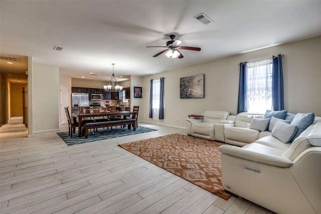 2446 Catherine St, Dallas, TX 75211 - living area with ceiling fan, a chandelier, plenty of natural light, and light wood-style flooring