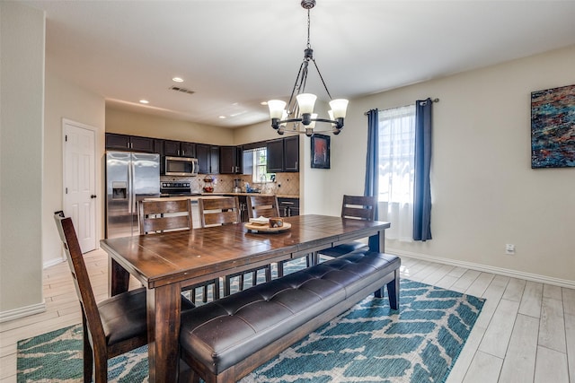 2446 Catherine St, Dallas, TX 75211 - dining space featuring a chandelier, light wood-type flooring, baseboards, healthy amount of natural light, and recessed lighting