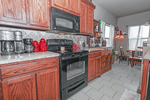 4109 Seminole Trl, Granbury, TX 76048 - kitchen with black appliances, backsplash, light countertops, and brown cabinetry