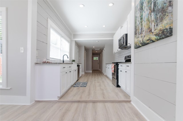 916 Wilde St, Denison, TX 75020 - kitchen featuring appliances with stainless steel finishes, light wood-style flooring, white cabinets, baseboards, and light stone counters