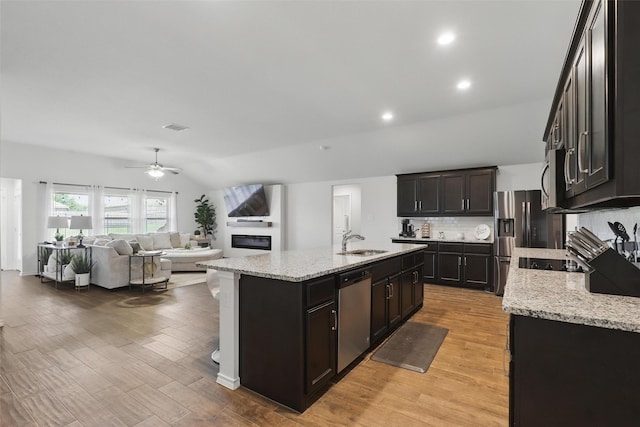 1417 Grassy Meadows Dr, Burleson, TX 76058 - kitchen featuring stainless steel appliances, a sink, a glass covered fireplace, ceiling fan, and open floor plan