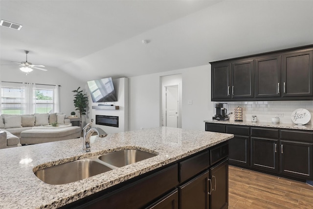 1417 Grassy Meadows Dr, Burleson, TX 76058 - kitchen featuring vaulted ceiling, a sink, light wood-style flooring, a ceiling fan, and backsplash