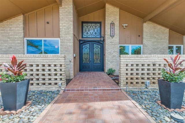 3984 Goodfellow Dr, Dallas, TX 75229 - doorway to property featuring board and batten siding, brick siding, and covered porch