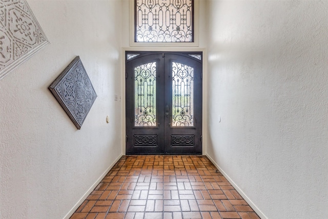 3984 Goodfellow Dr, Dallas, TX 75229 - entrance foyer with brick floors, french doors, a towering ceiling, and baseboards