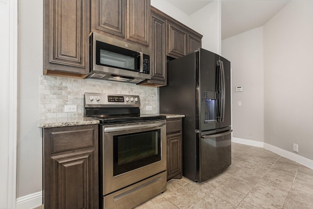 628 Cottage Pl, Lavon, TX 75166 - kitchen with appliances with stainless steel finishes, tasteful backsplash, dark brown cabinets, baseboards, and light stone countertops