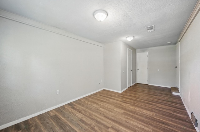 1043 Star St, Denison, TX 75020 - empty room with wood finished floors, baseboards, and a textured ceiling