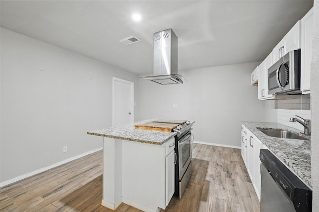 1043 Star St, Denison, TX 75020 - kitchen featuring island range hood, a sink, stainless steel appliances, and light stone countertops