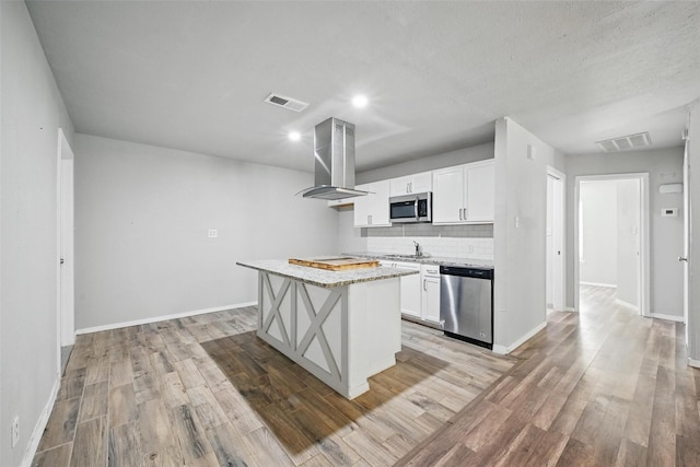 1043 Star St, Denison, TX 75020 - kitchen featuring stainless steel appliances, ventilation hood, light wood-style flooring, and recessed lighting