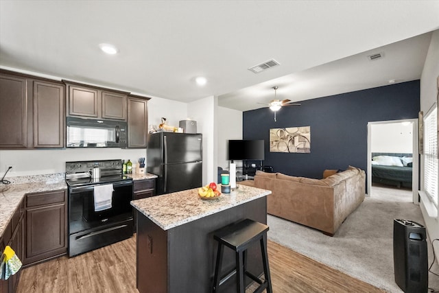 113 Hamilton Way, Venus, TX 76084 - kitchen featuring black appliances, a center island, dark brown cabinetry, light wood finished floors, and a ceiling fan