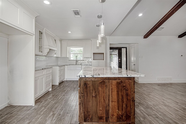 3408 Walton Ave, Fort Worth, TX 76133 - kitchen with light wood finished floors, tasteful backsplash, light stone countertops, a sink, and a center island