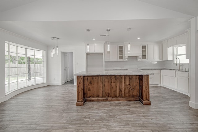 3408 Walton Ave, Fort Worth, TX 76133 - kitchen featuring vaulted ceiling, a sink, tasteful backsplash, white cabinetry, and a kitchen island
