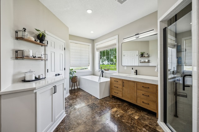 18818 Webb Ln, Nevada, TX 75173 - bathroom featuring two vanities, a shower stall, a freestanding tub, recessed lighting, and a textured ceiling