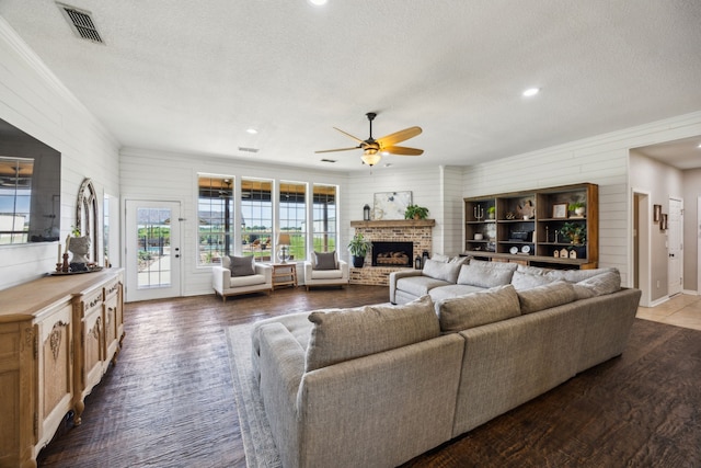 18818 Webb Ln, Nevada, TX 75173 - living room with a ceiling fan, a textured ceiling, wood finished floors, a brick fireplace, and wood walls
