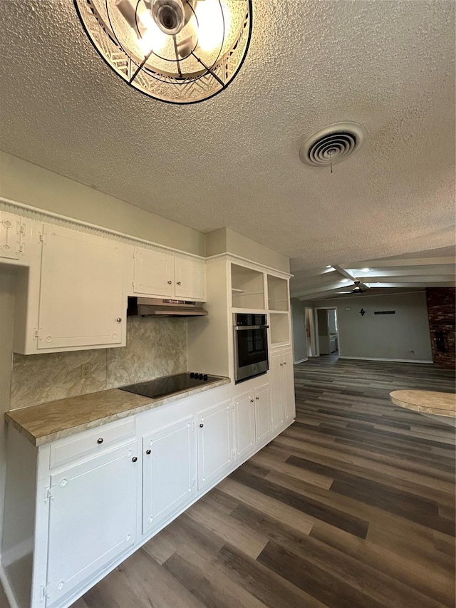 3026 San Miguel Dr, Abilene, TX 79605 - kitchen featuring wall oven, dark wood-style floors, a textured ceiling, white cabinets, and under cabinet range hood