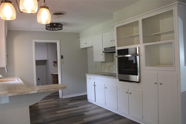 3026 San Miguel Dr, Abilene, TX 79605 - kitchen featuring oven, dark wood finished floors, white cabinetry, light countertops, and under cabinet range hood