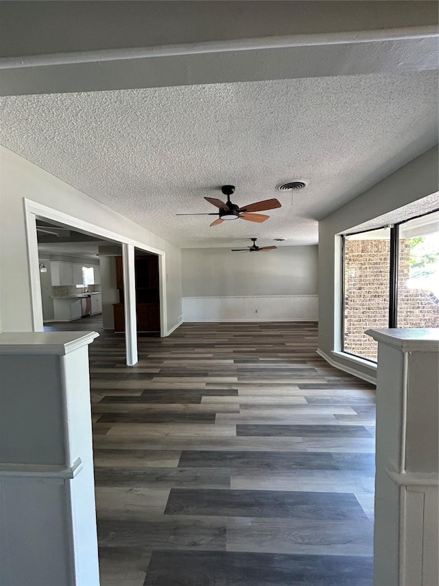 3026 San Miguel Dr, Abilene, TX 79605 - unfurnished living room featuring wood finished floors, a ceiling fan, a textured ceiling, and baseboards