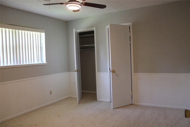 3026 San Miguel Dr, Abilene, TX 79605 - unfurnished bedroom with wainscoting, a textured ceiling, carpet floors, and a ceiling fan