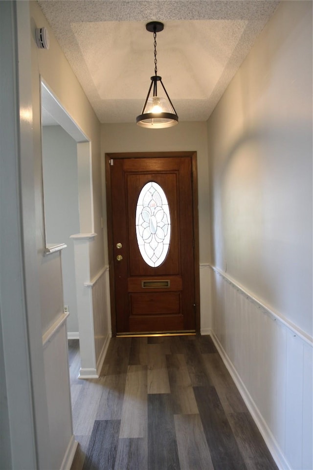 3026 San Miguel Dr, Abilene, TX 79605 - entrance foyer with dark wood-style floors, a textured ceiling, a wainscoted wall, and a decorative wall
