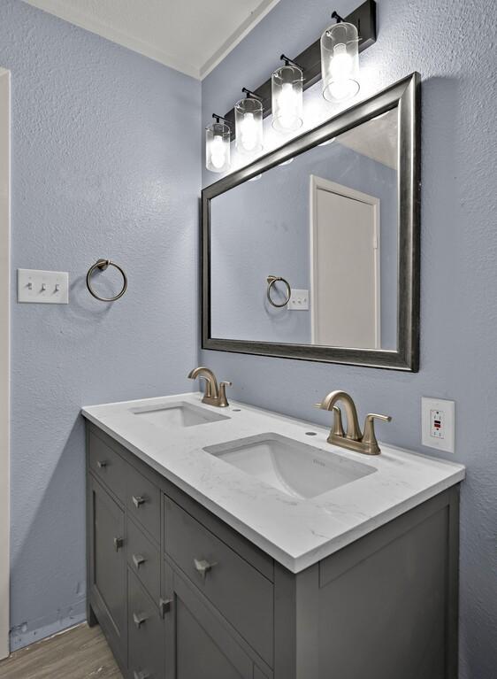 509 E Pine St, West, TX 76691 - full bath featuring double vanity, a textured wall, and wood finished floors