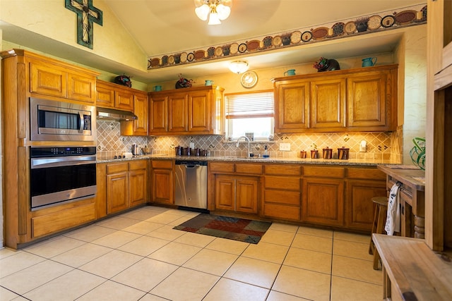 279 County Road 3470, Paradise, TX 76073 - kitchen featuring appliances with stainless steel finishes, lofted ceiling, a sink, brown cabinetry, and backsplash