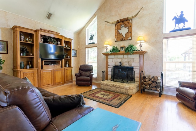 279 County Road 3470, Paradise, TX 76073 - living room featuring wood finished floors, a stone fireplace, high vaulted ceiling, and a textured wall
