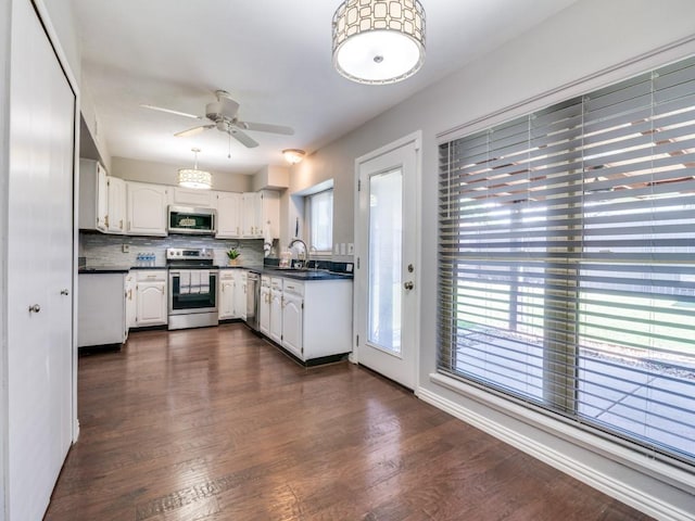 4552 Fremont Ln, Plano, TX 75093 - kitchen featuring stainless steel appliances, a sink, a ceiling fan, dark countertops, and white cabinets