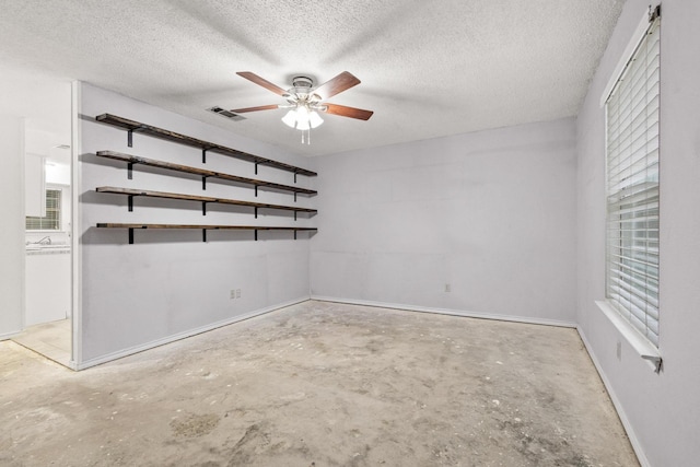 453 County Road 2521, Bonham, TX 75418 - unfurnished room with unfinished concrete flooring, a ceiling fan, baseboards, and a textured ceiling
