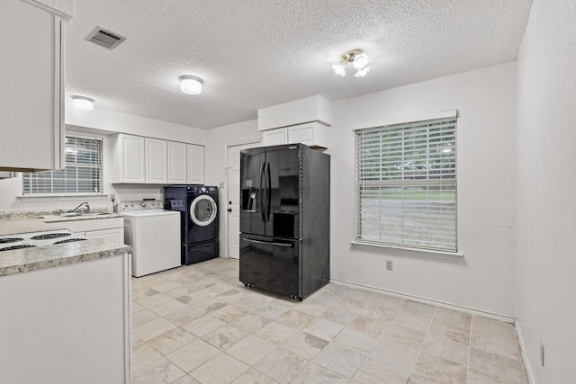 453 County Road 2521, Bonham, TX 75418 - kitchen featuring black refrigerator with ice dispenser, washer and clothes dryer, white cabinetry, a sink, and a textured ceiling
