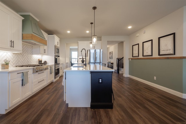 664 Fletcher Dr, Fate, TX 75087 - kitchen featuring appliances with stainless steel finishes, baseboards, custom range hood, decorative backsplash, and a sink