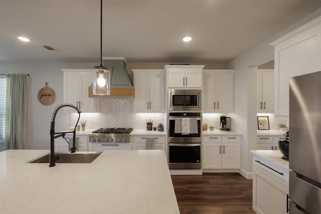 664 Fletcher Dr, Fate, TX 75087 - kitchen with stainless steel appliances, a sink, tasteful backsplash, hanging light fixtures, and recessed lighting