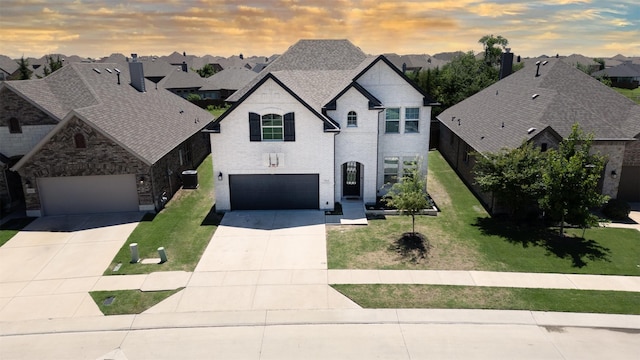 664 Fletcher Dr, Fate, TX 75087 - french country style house featuring a residential view, driveway, a yard, and brick siding