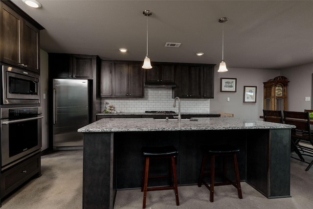 14447 Warbler Ln, Haslet, TX 76052 - kitchen with stainless steel appliances, light carpet, backsplash, light stone counters, and dark brown cabinetry